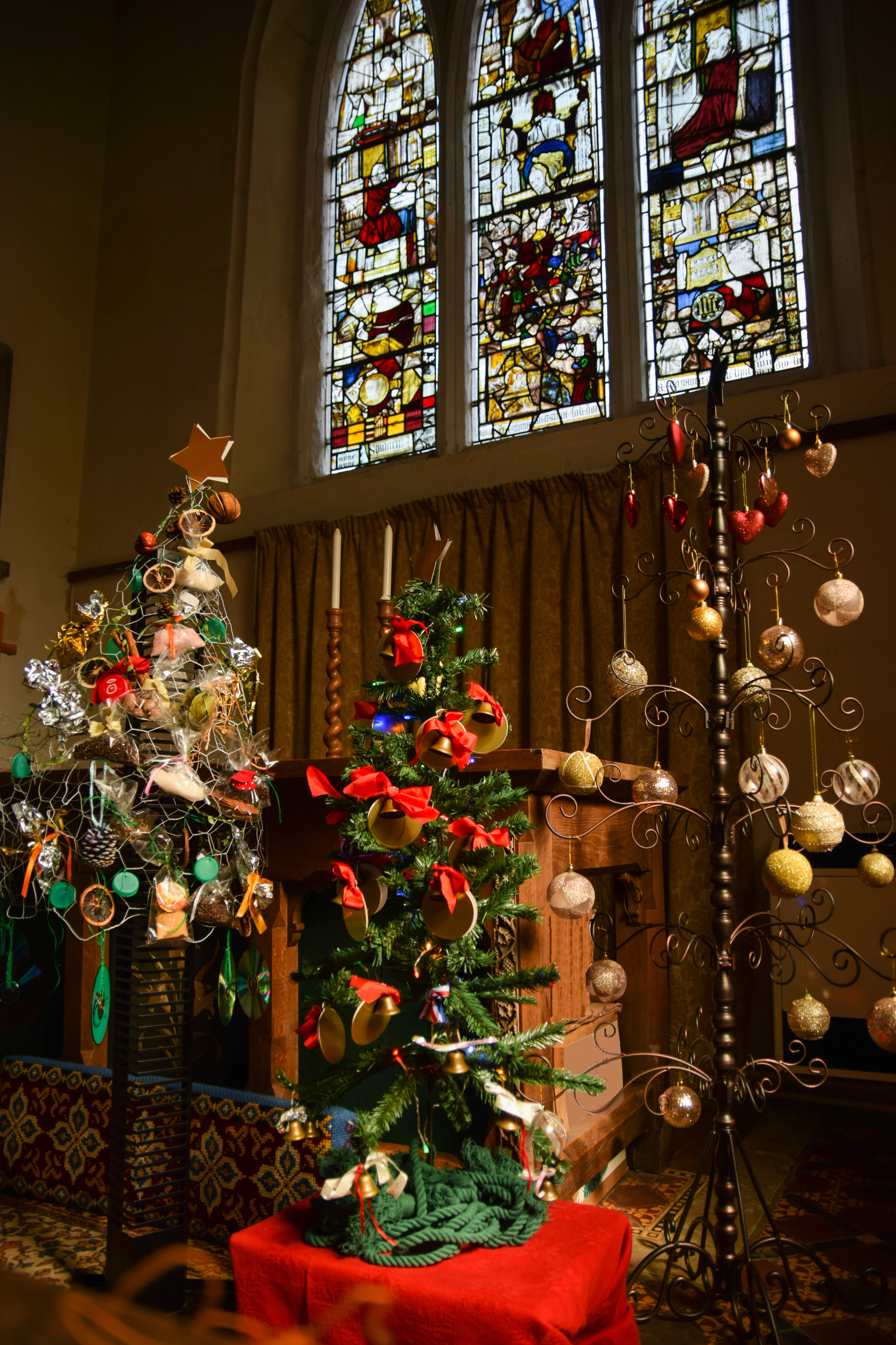 christmas trees in front of stained glass window